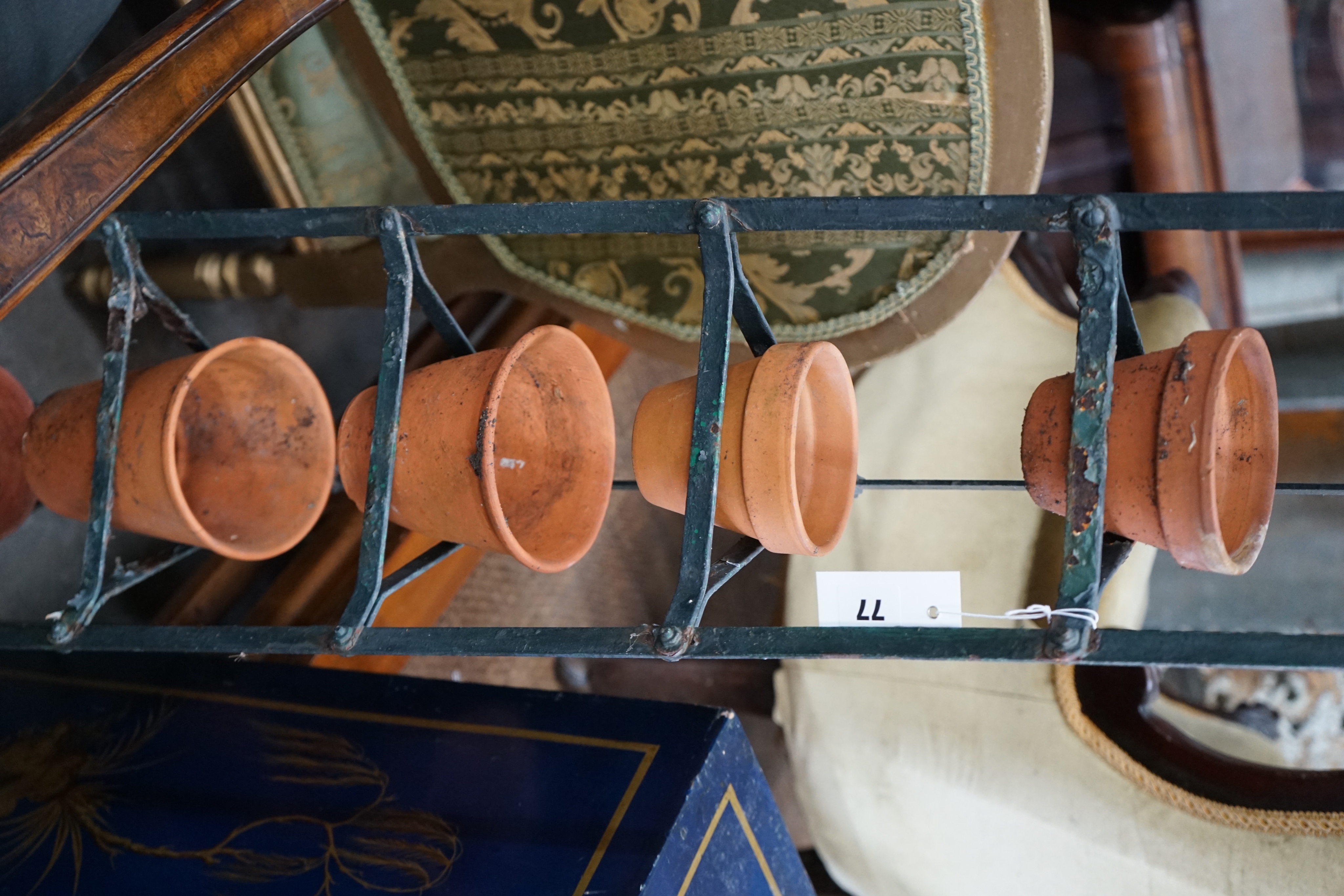 A wrought iron six tier pot stand, together with six terracotta pots, height 143cm